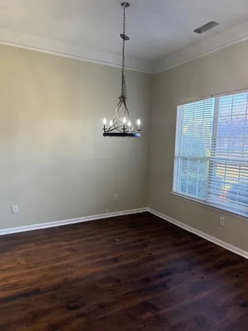 a view of a room with wooden floor chandelier and window