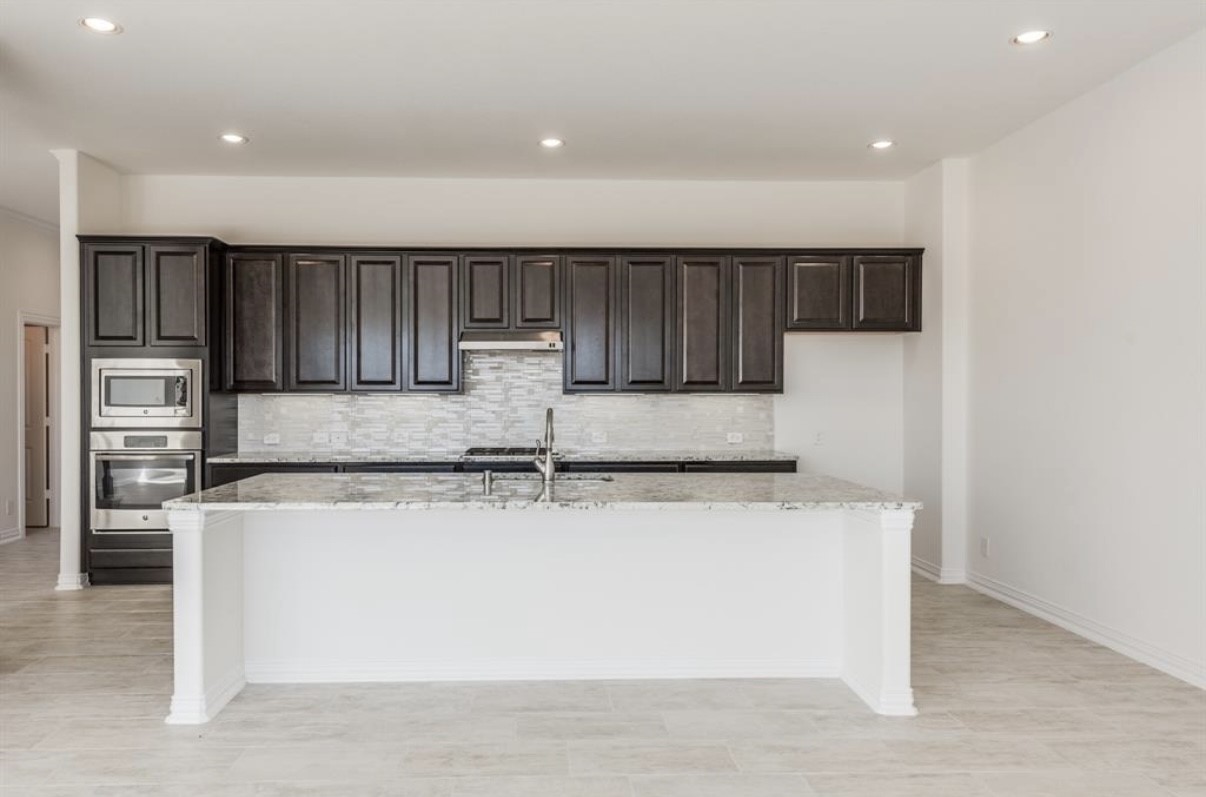 3223 Harmony Creek Lane Spring, TX 77386 - Photo 11 of 34 a kitchen with stainless steel appliances granite countertop a sink a stove a microwave and a refrigerator