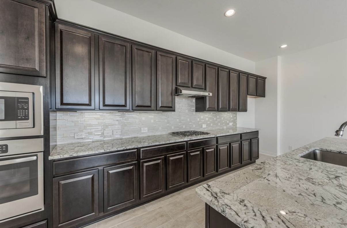 3223 Harmony Creek Lane Spring, TX 77386 - Photo 12 of 34 a kitchen with stainless steel appliances granite countertop wooden cabinets a sink and dishwasher