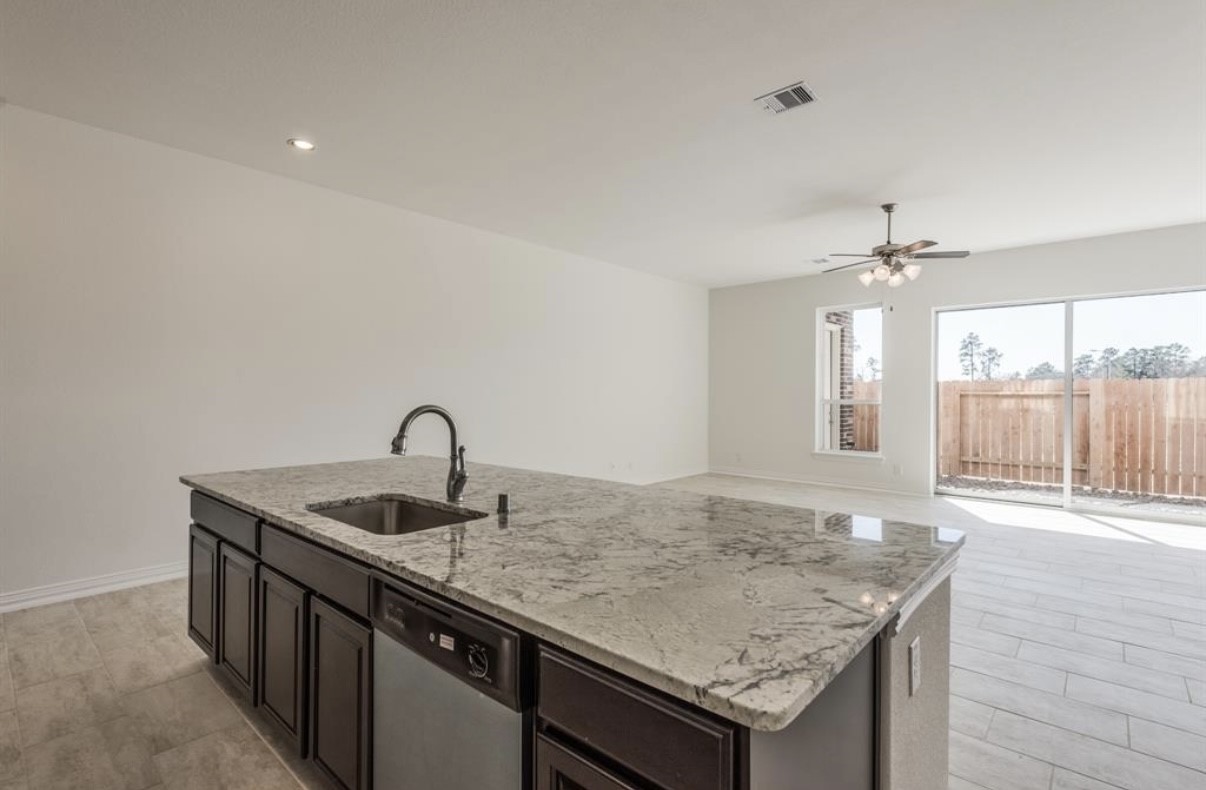 3223 Harmony Creek Lane Spring, TX 77386 - Photo 16 of 34 a kitchen with granite countertop a sink and a wooden floor
