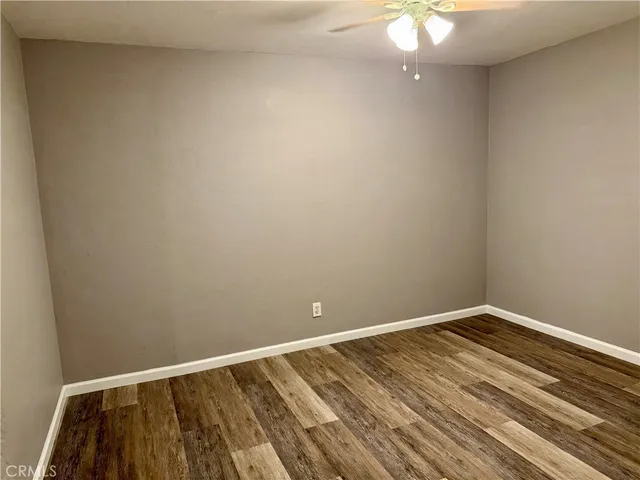 a view of a room with wooden floor and fan