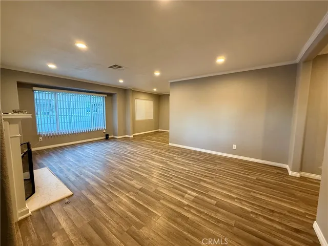 an empty room with wooden floor and mirrors