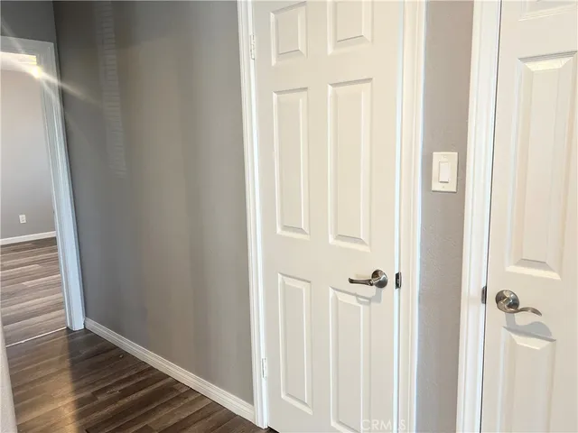 a view of a hallway with wooden floor and closet area