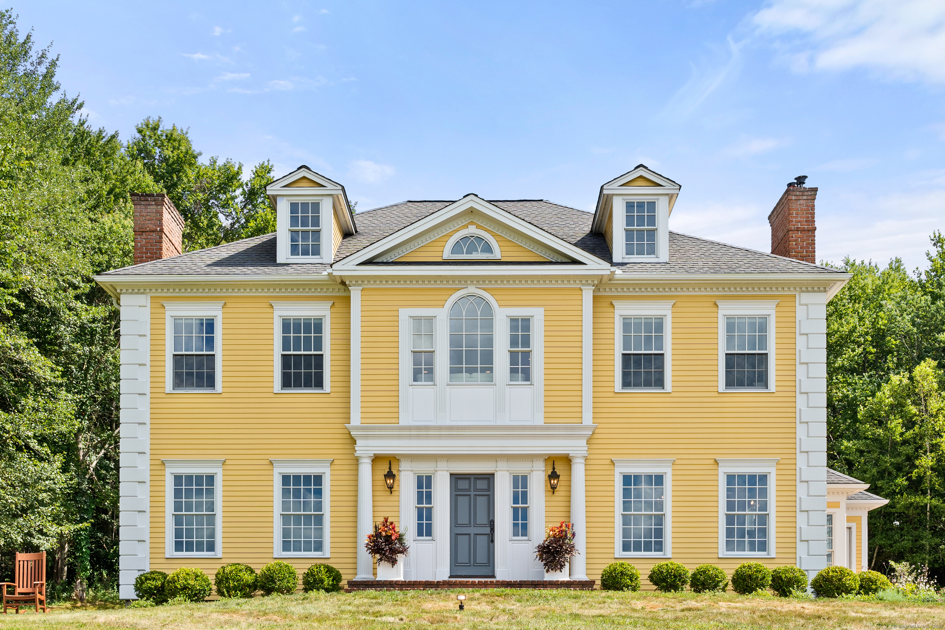 a front view of a residential apartment building with windows and yard