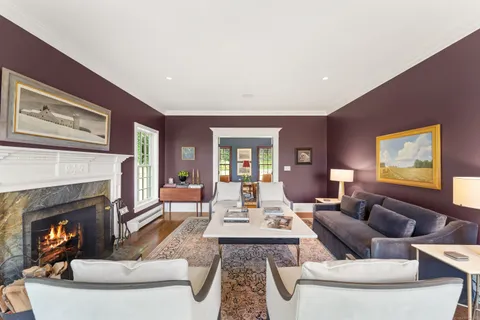 a living room with furniture a large window and a fireplace