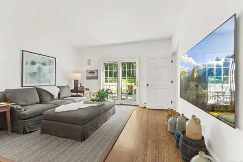 a living room with furniture and a dining table with wooden floor