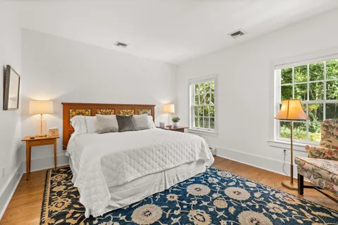 a bedroom with a bed chair and a window