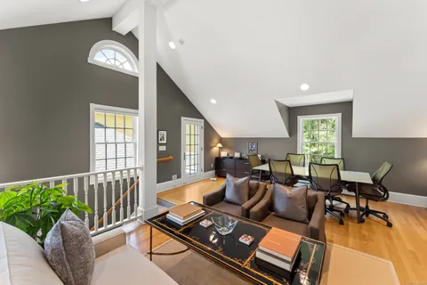 a bedroom with a bed and a large window with wooden floor