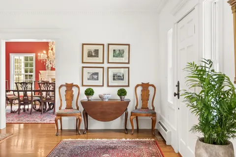 a dining room with furniture potted plants and wooden floor