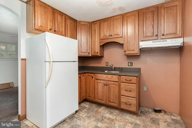 a kitchen with granite countertop a sink cabinets stainless steel appliances and a window