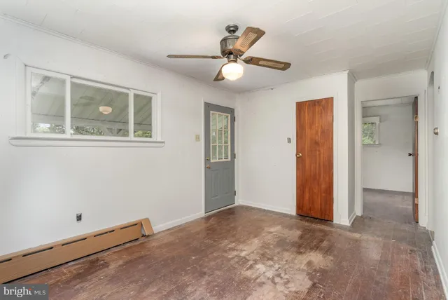 an empty room with a ceiling fan and a window