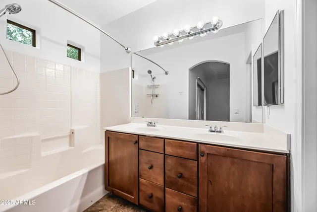 a bathroom with a tub sink and mirror