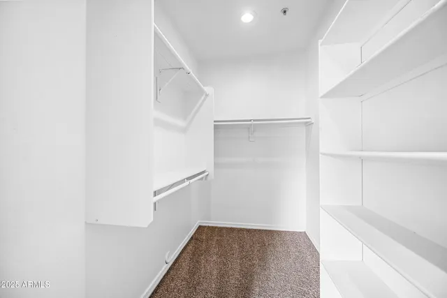 a view of walk in closet with empty racks