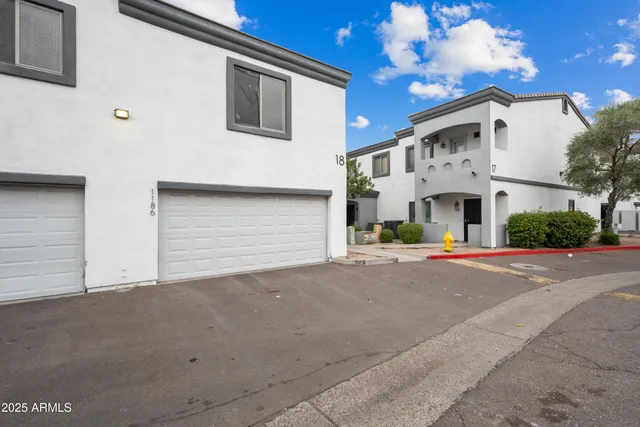 a view of white house with a road and garage
