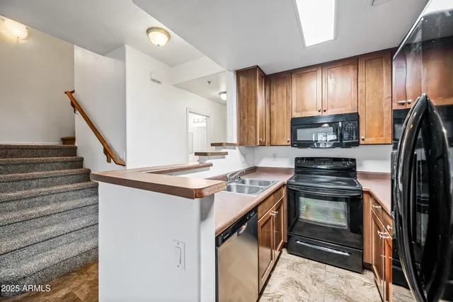 a kitchen with granite countertop wooden cabinets and stainless steel appliances