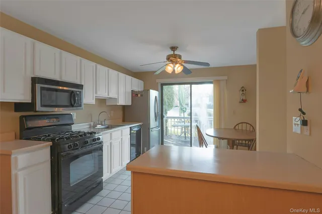 a kitchen with kitchen island a sink appliances cabinets and a counter top space