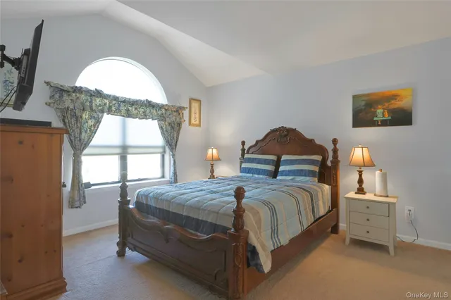 a bedroom with a bed and a large window