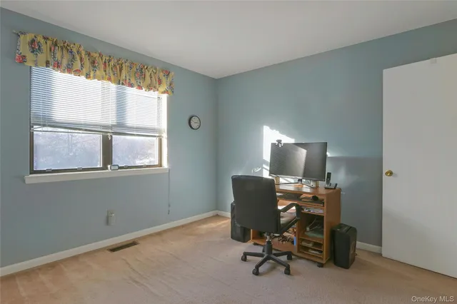 a view of a workspace with furniture and a window
