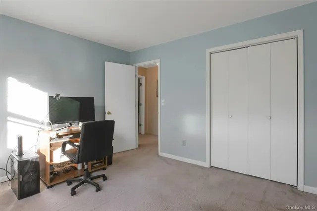 a view of a workspace with furniture and a window