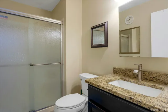 a bathroom with a granite countertop sink toilet and shower