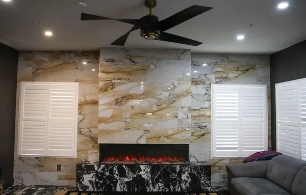 a living room with furniture a flat screen tv and a fireplace