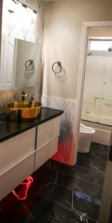 a bathroom with a granite countertop bathtub shower and toilet