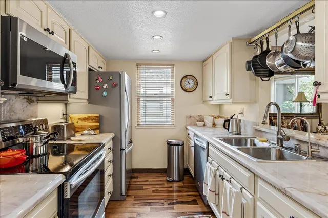 a kitchen with stainless steel appliances granite countertop a sink stove and refrigerator