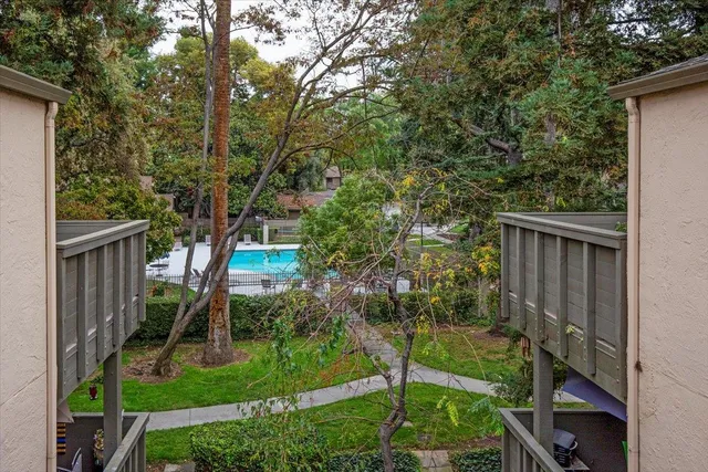 a backyard of a house with plants and wooden fence