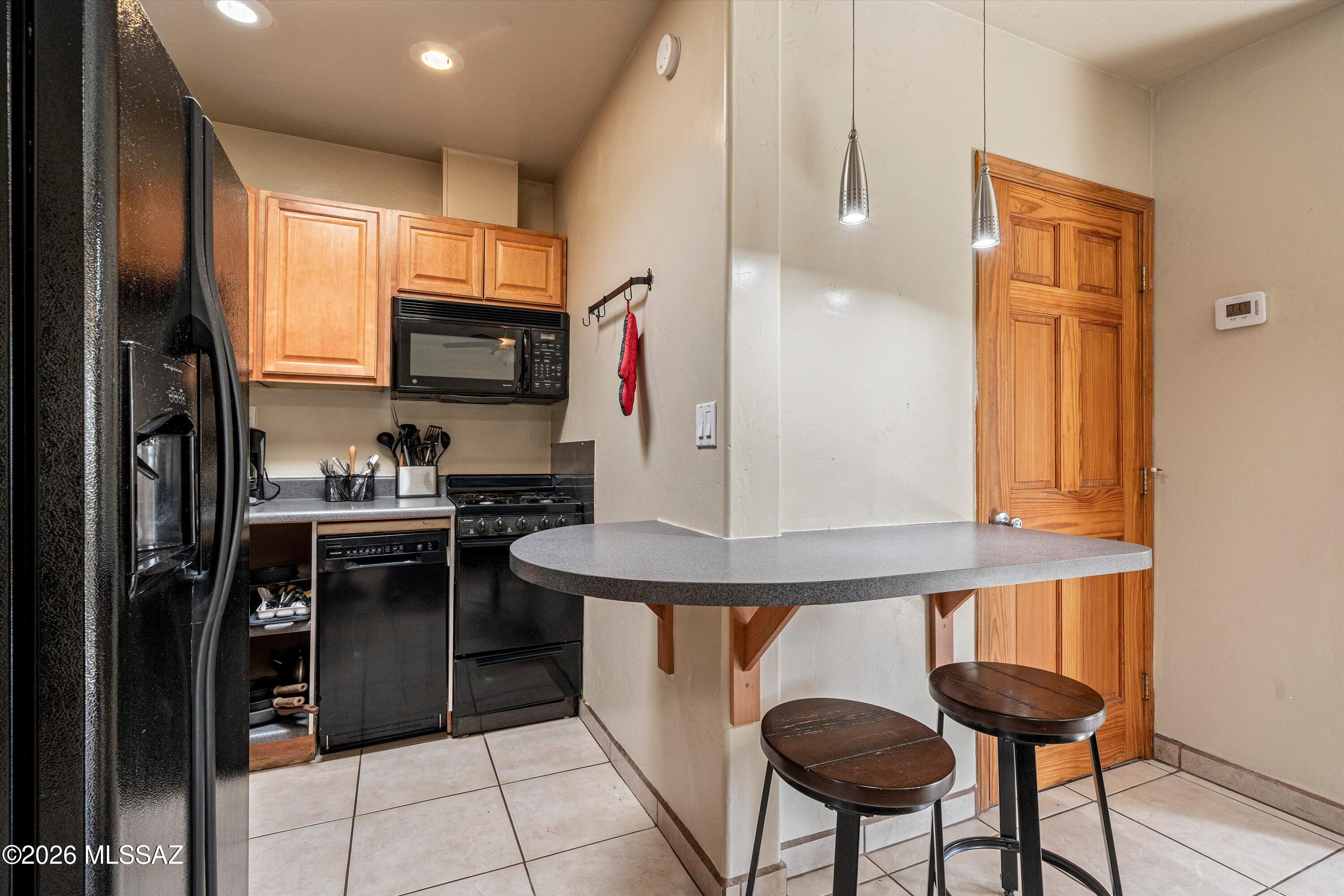 2619 East Prince Road Tucson, AZ 85716 - Photo 36 of 50 a kitchen with stainless steel appliances granite countertop a refrigerator and a stove top oven