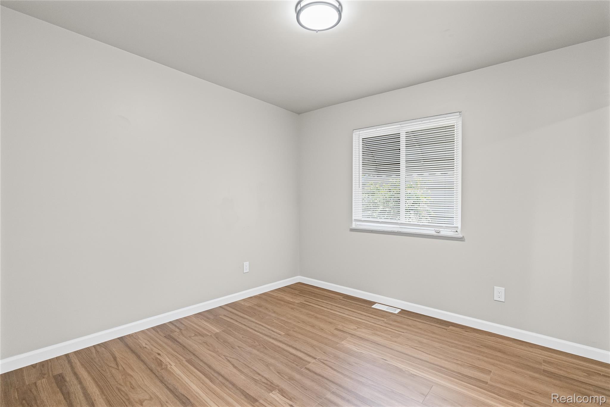 3710 Branch Road Flint, MI 48506 - Photo 23 of 46 Room featuring wood-finish flooring, light gray walls, white trim, and a window with blinds