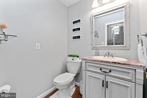 a bathroom with a granite countertop toilet sink and mirror