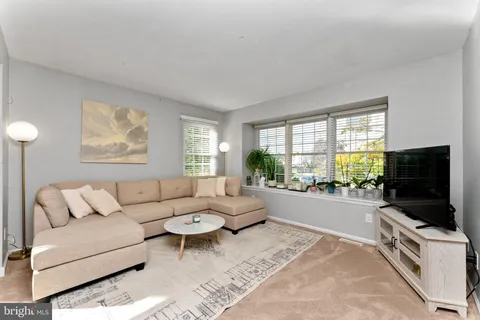 a living room with furniture a flat screen tv and a large window
