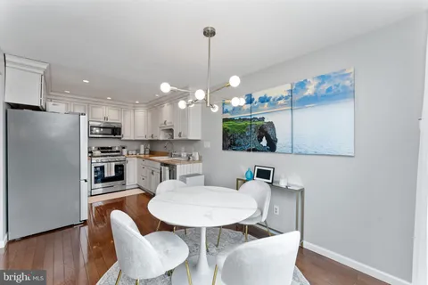 a kitchen with kitchen island a dining table and chairs