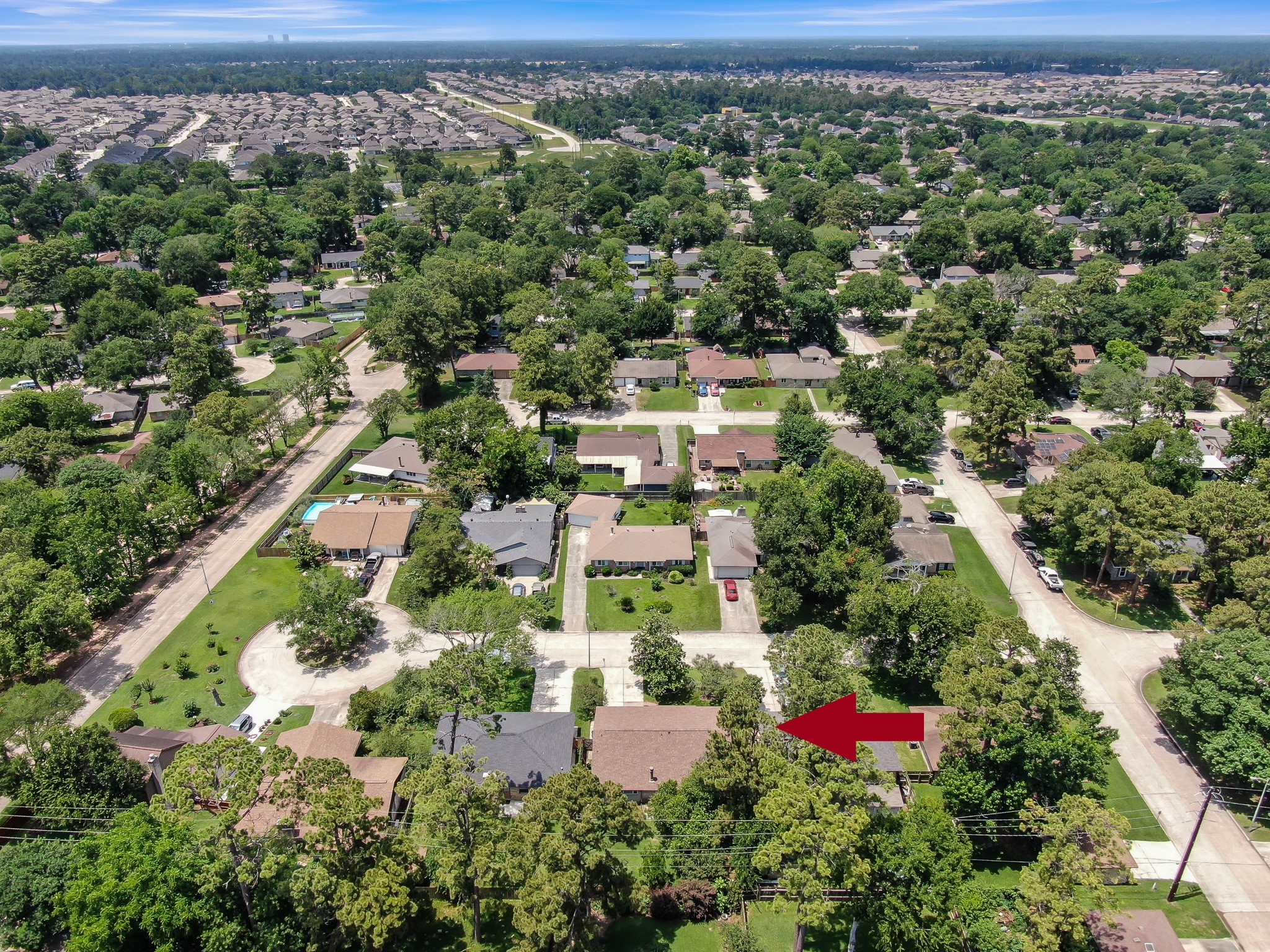 4314 Enchantedgate Drive Spring, TX 77373 - Photo 45 of 47 Aerial photo showcases a suburban neighborhood with lush greenery and well-maintained homes. The house indicated by the red arrow is situated on a quiet street, surrounded by mature trees, providing a serene and private setting.