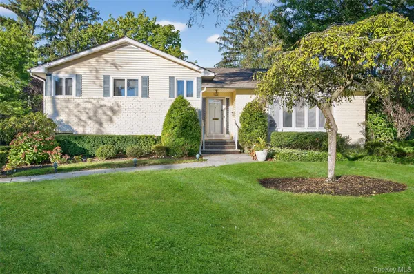 a view of a house with a yard and potted plants