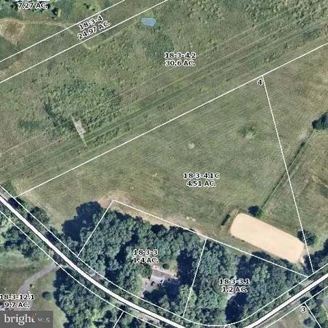 a view of a green field with wooden fence