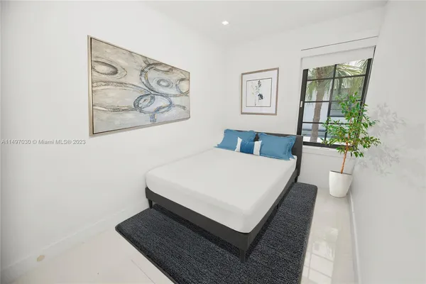 a bedroom with a bed and painting on the wall