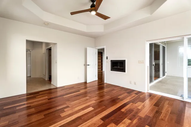 a view of an empty room with wooden floor
