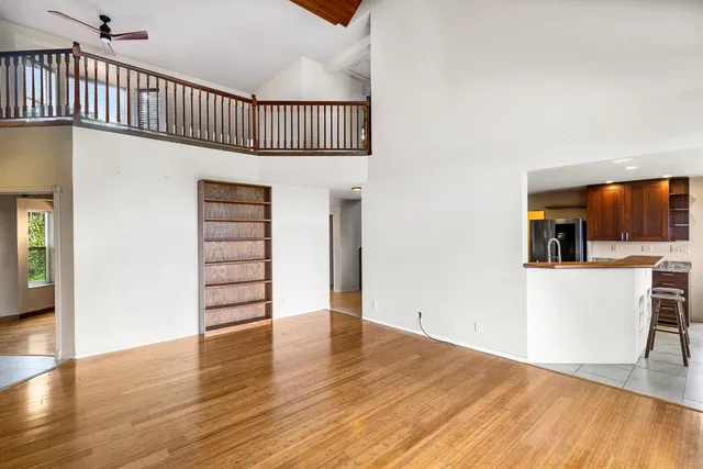 a view of a hallway with wooden floor and staircase