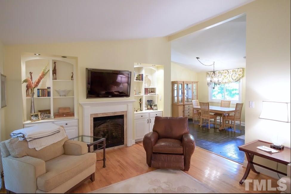 1205 Gunnison Place Raleigh, NC 27609 - Photo 4 of 14 a living room with furniture a flat screen tv and a fireplace