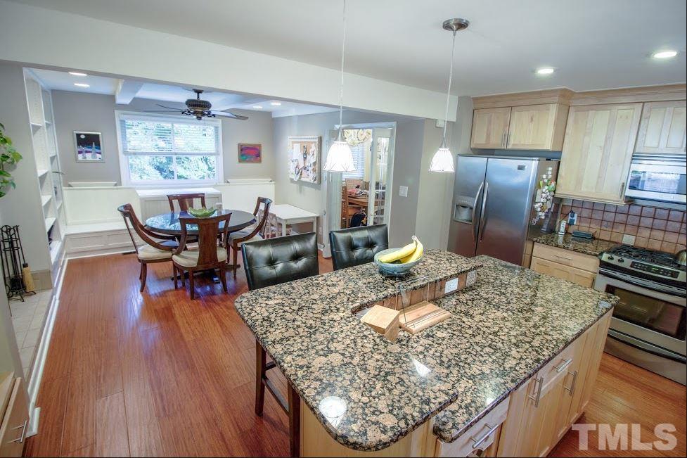 1205 Gunnison Place Raleigh, NC 27609 - Photo 6 of 14 a living room with dining table and wooden floor