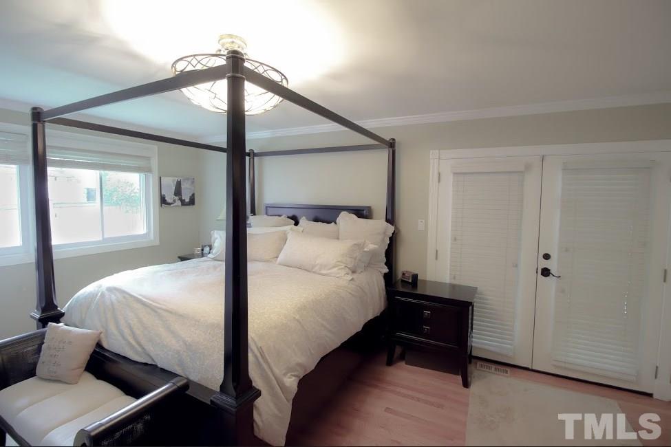 1205 Gunnison Place Raleigh, NC 27609 - Photo 9 of 14 a bedroom with a bed and a chandelier