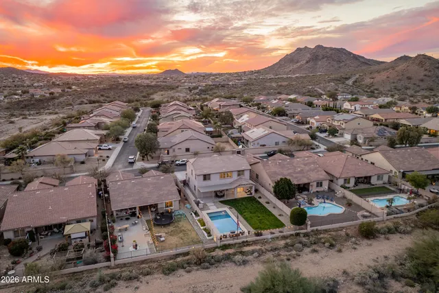 a kitchen with stainless steel appliances granite countertop a refrigerator a stove a sink a dining table and chairs