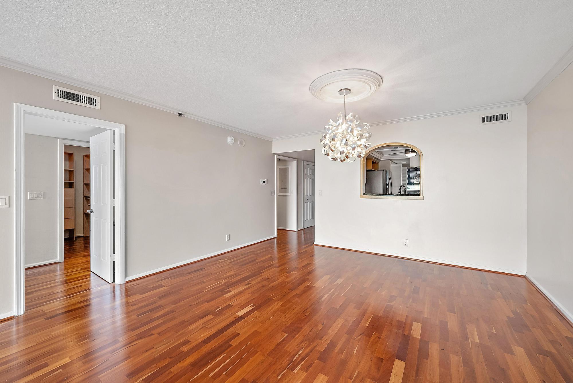 356 Golfview Road, Unit 805 North Palm Beach, FL 33408 - Photo 9 of 29 an empty room with wooden floor chandelier and windows