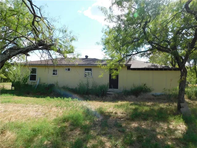 a view of backyard with a barn and large trees