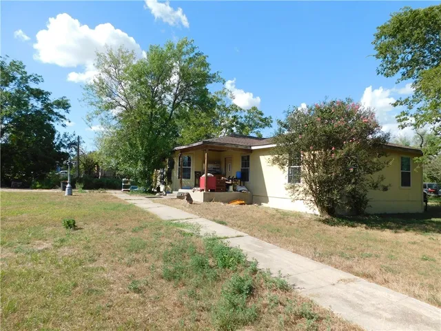a view of a house with backyard and sitting area
