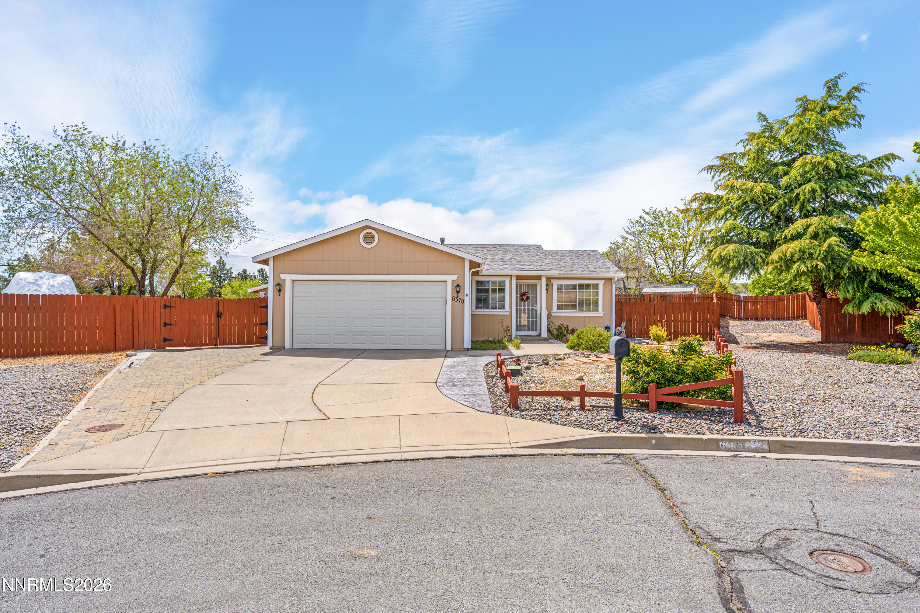 front view of a house with a yard and potted plants