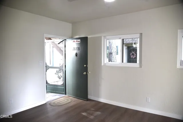 an empty room with wooden floor and a window
