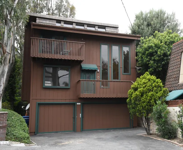 a view of a house with a balcony and plants