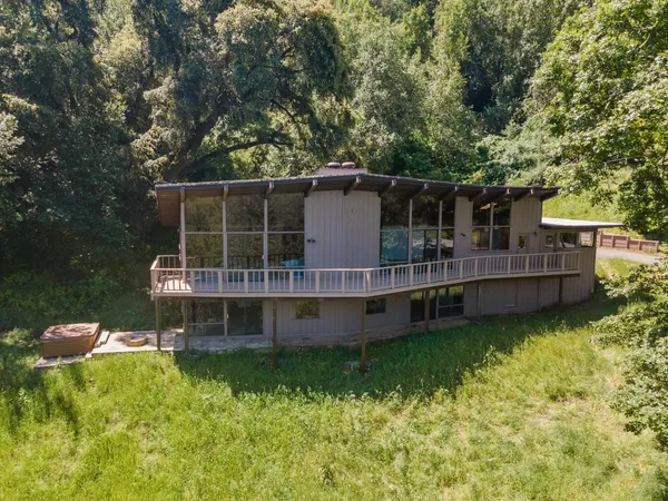 a view of a house with backyard outdoor seating and deck